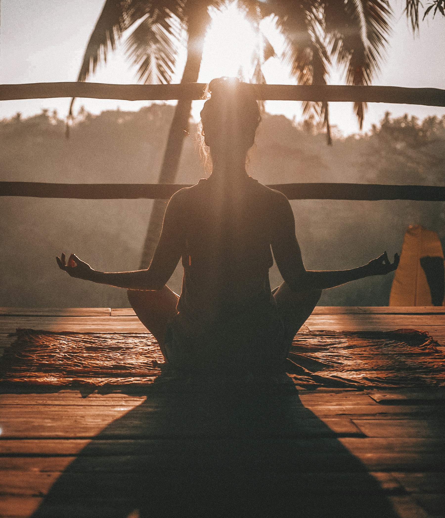 Femme en méditation au lever du soleil, silhouette sereine face à la nature